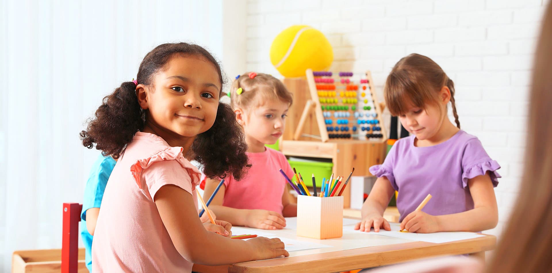 children drawing something using colored pencils