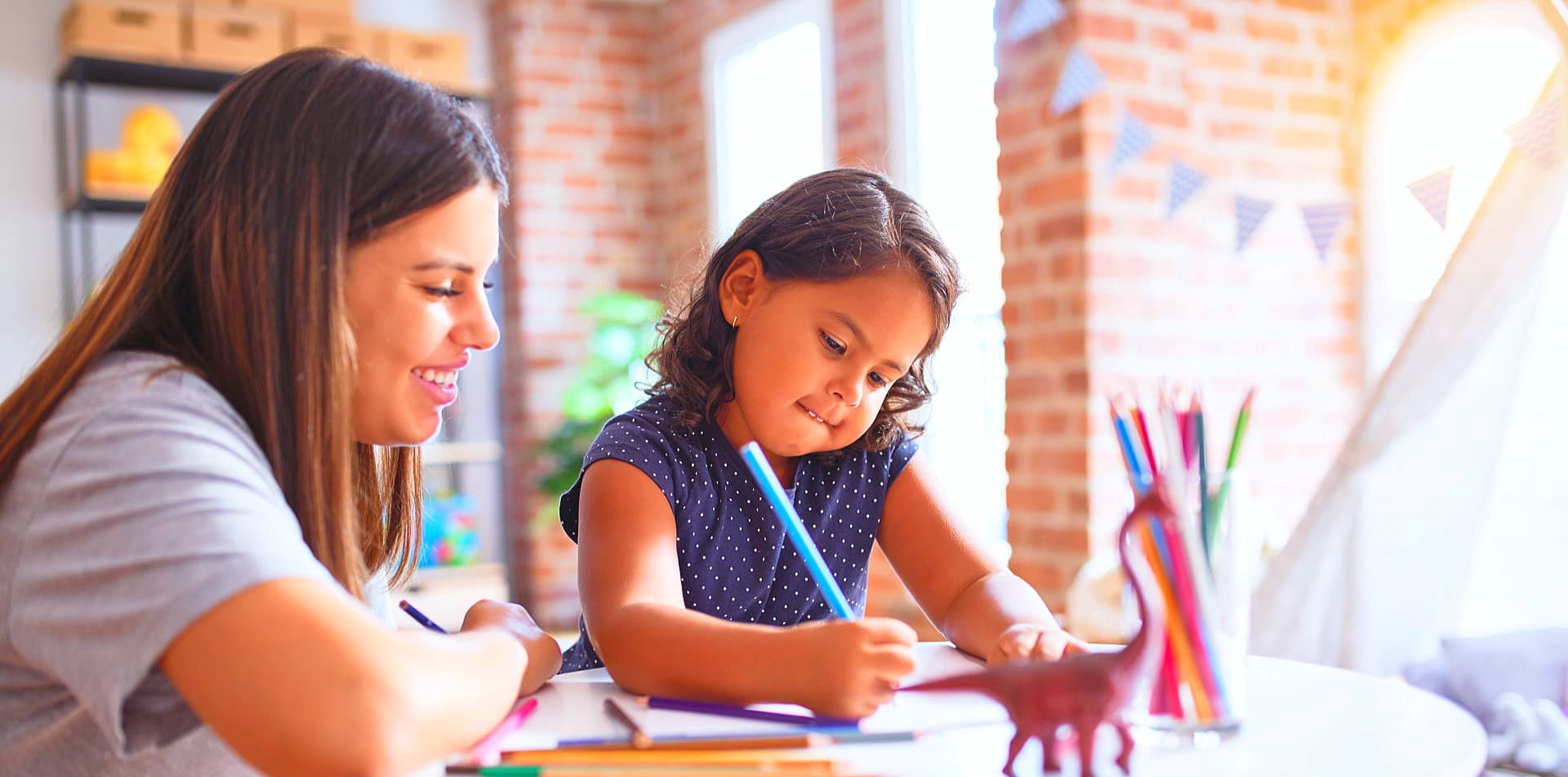 children drawing something using colored pencils
